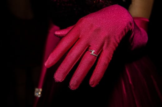 Mano con un guante rojo y un anillo