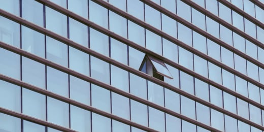 Fachada de un edificio acristalado con una ventana abierta