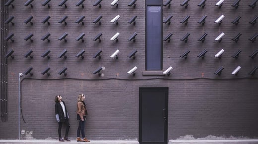 Dos mujeres mirando una fachada llena de cámaras de vigilancia